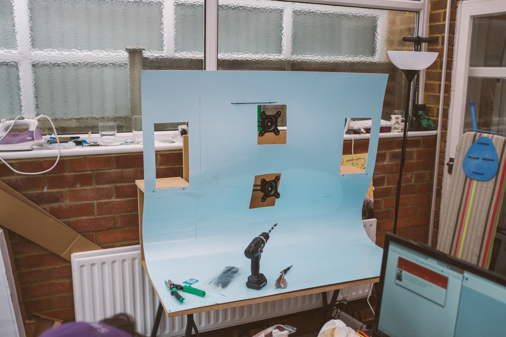 the white PVC draped over the structure and bent to form the shape of the desk, cutouts for the monitors and speakers, it still has the blue protective plastic over it