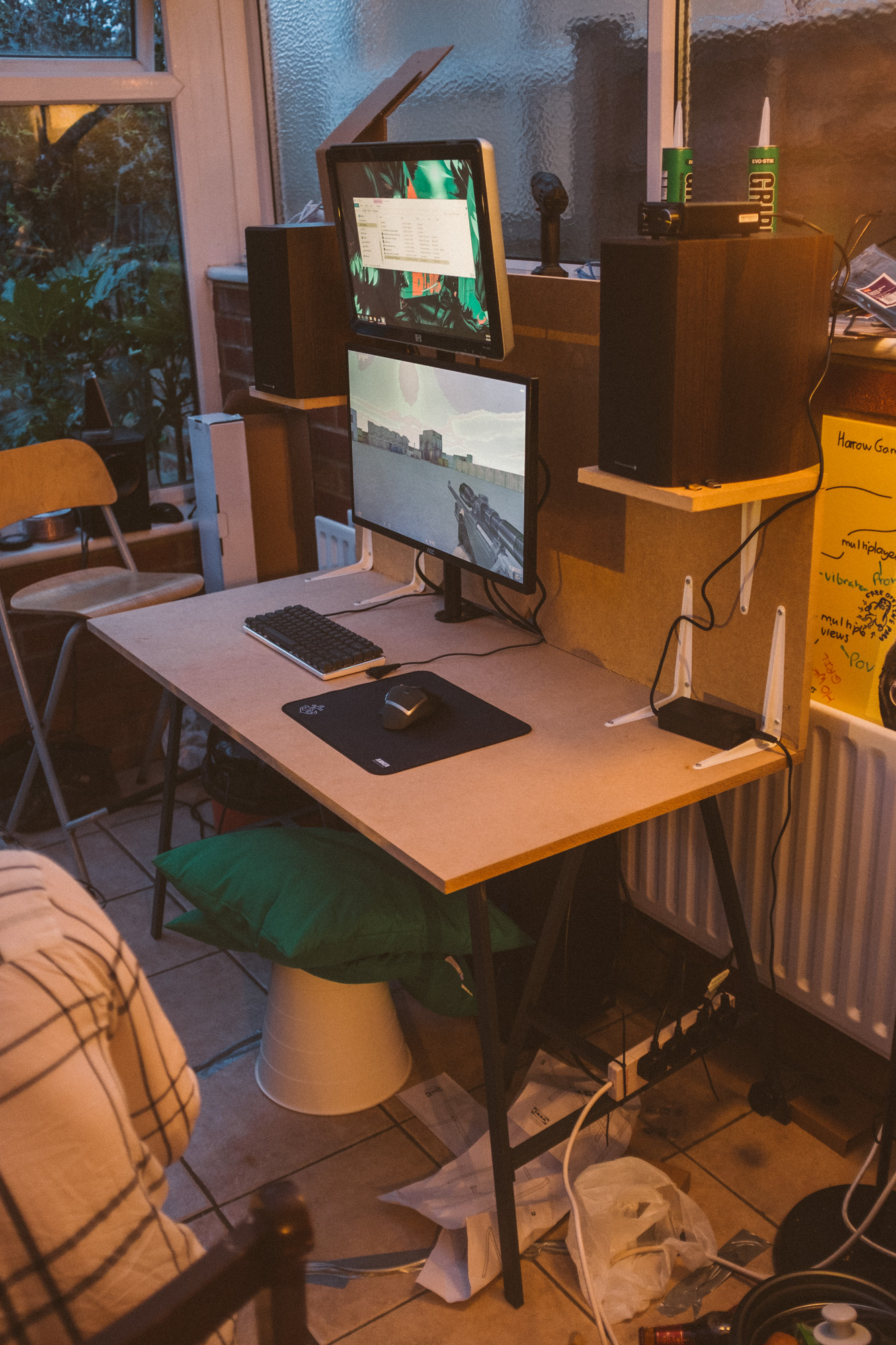 The desk with the MDF base, monitors, speakers, mouse and keyboard but no PVC covering, counter strike on the screen