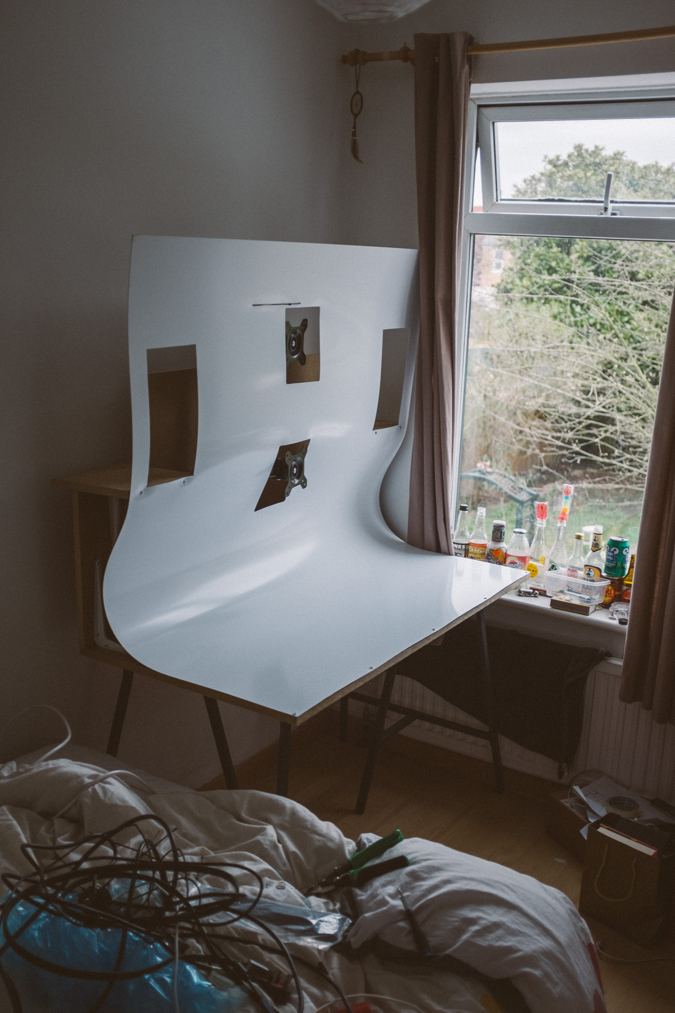 desk with PVC attached but no speakers, monitors etc. placed in a room next to a window