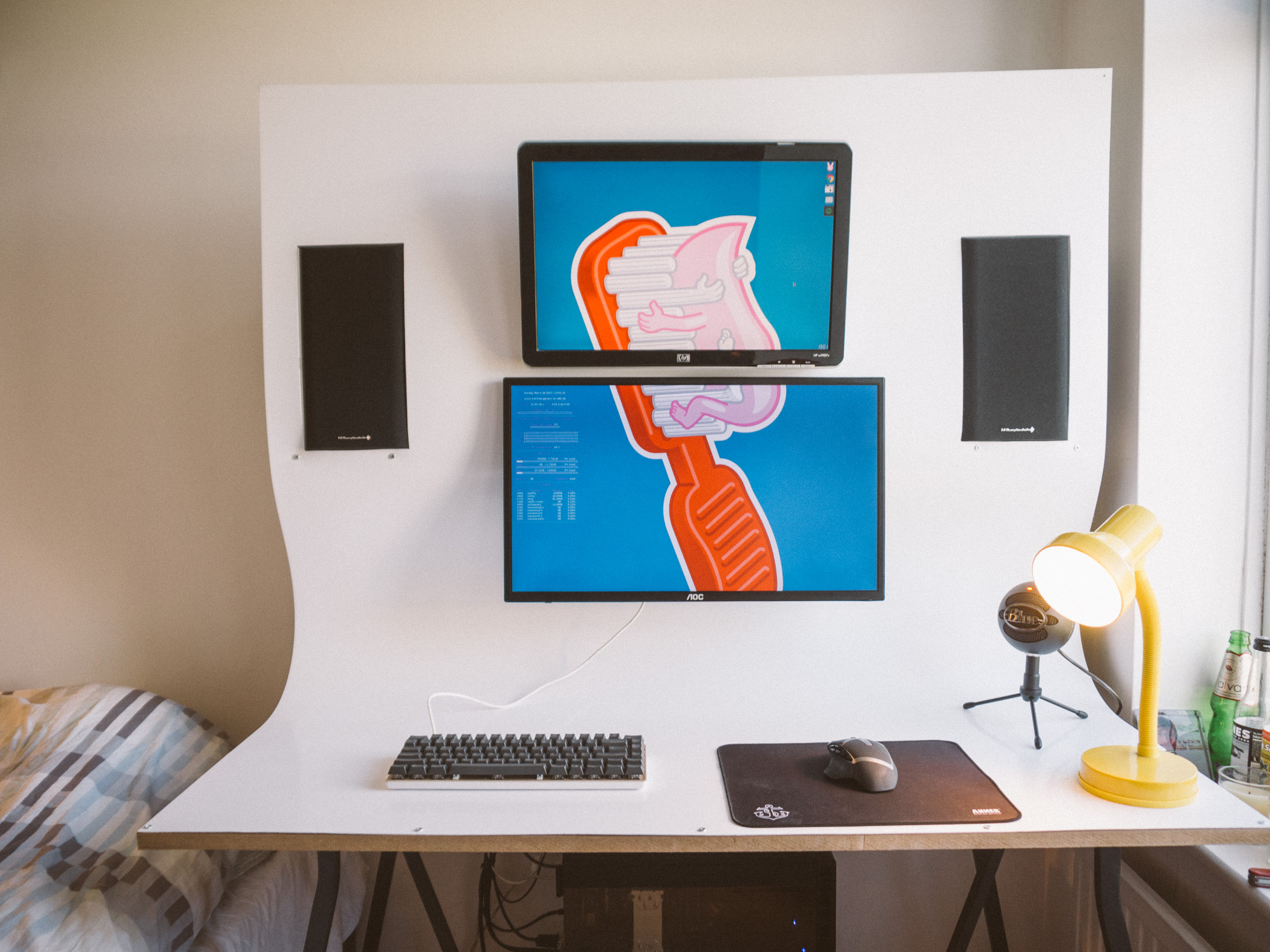 Desk set up properly, now has a yellow lamp and the two screens have a wallpaper that emphasises that it is all one unit by stretching across both