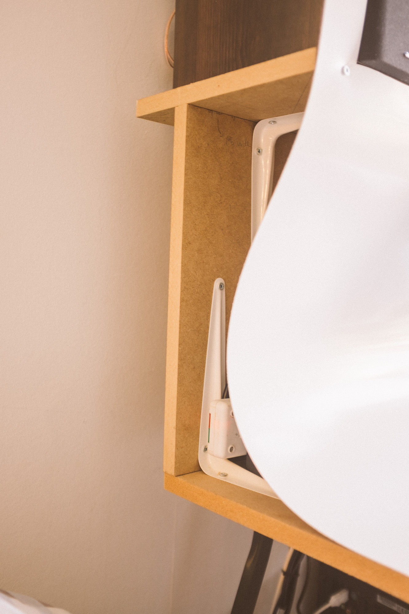 A close up of the the exposed MDF skeleton of the desk at the side, the PVC sheet only covering the front
