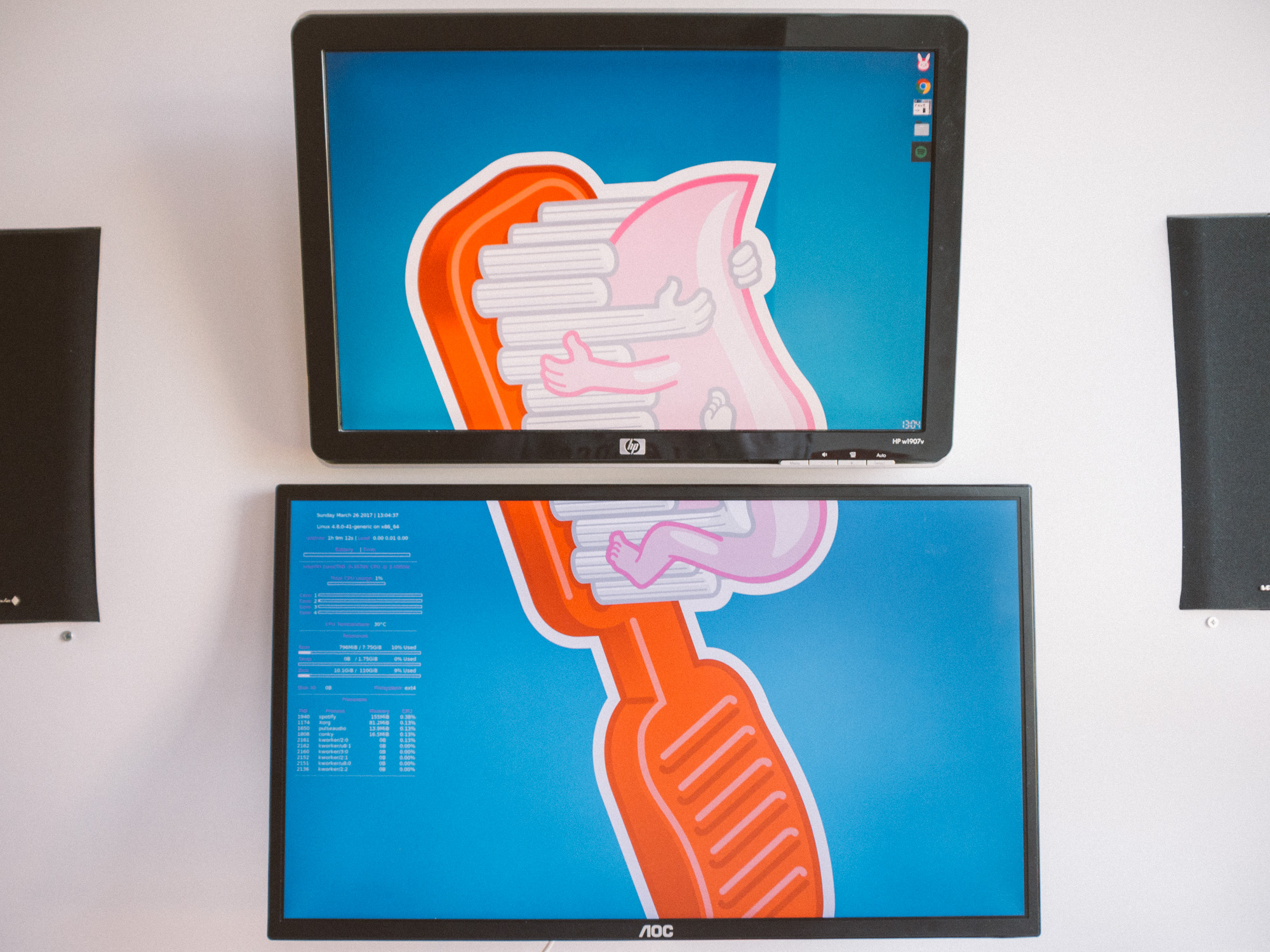 A close up of the two monitors with the toothpaste wallpaper stretching across both